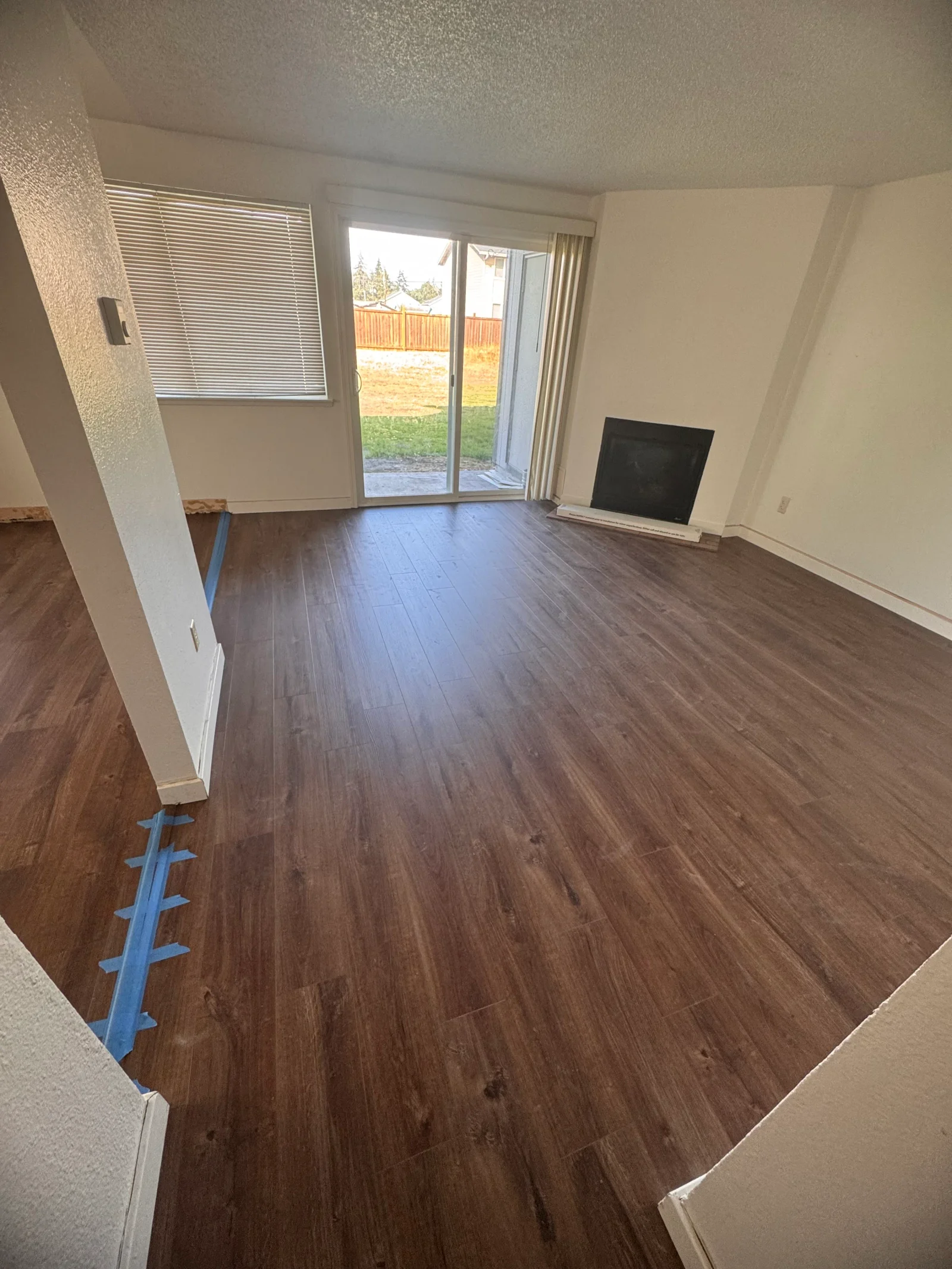 Dark wood-grain luxury vinyl plank flooring in living room with sliding glass doors