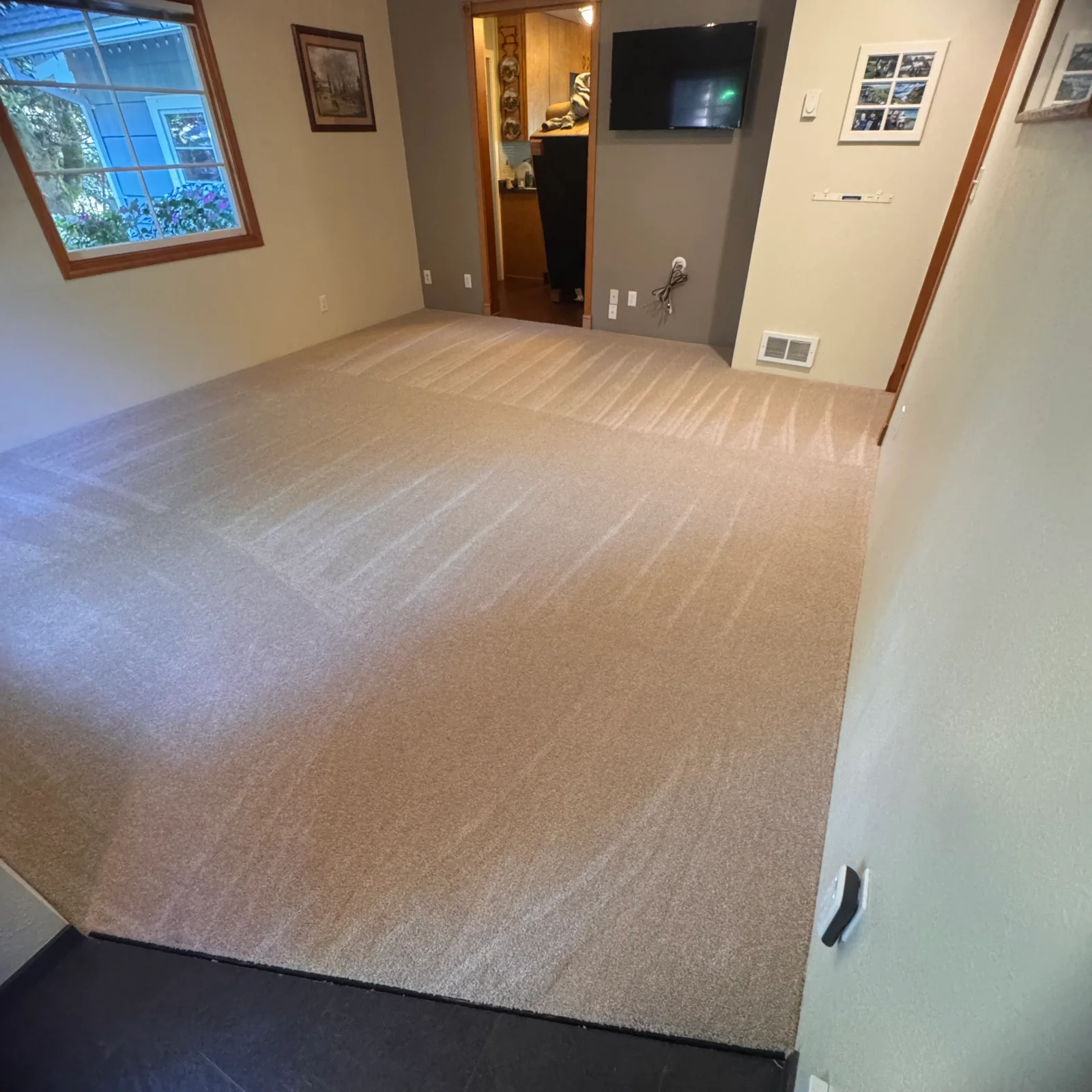 Newly installed neutral carpet with visible seaming patterns in finished basement room